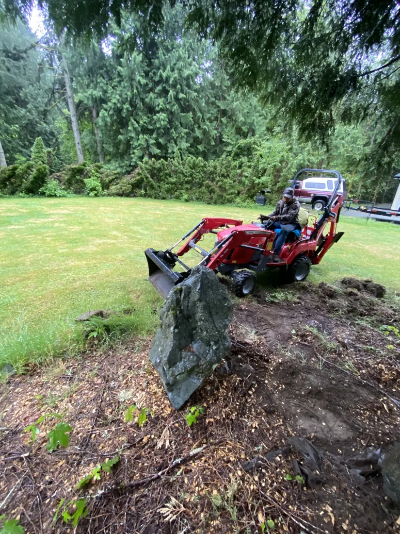 StarWise Ranch operator using a compact tractor and loader for landscape rock and earthwork